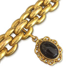 AN ANTIQUE 18K YELLOW GOLD AND GARNET LOCKET BRACELET, CIRCA MID 1900\'S